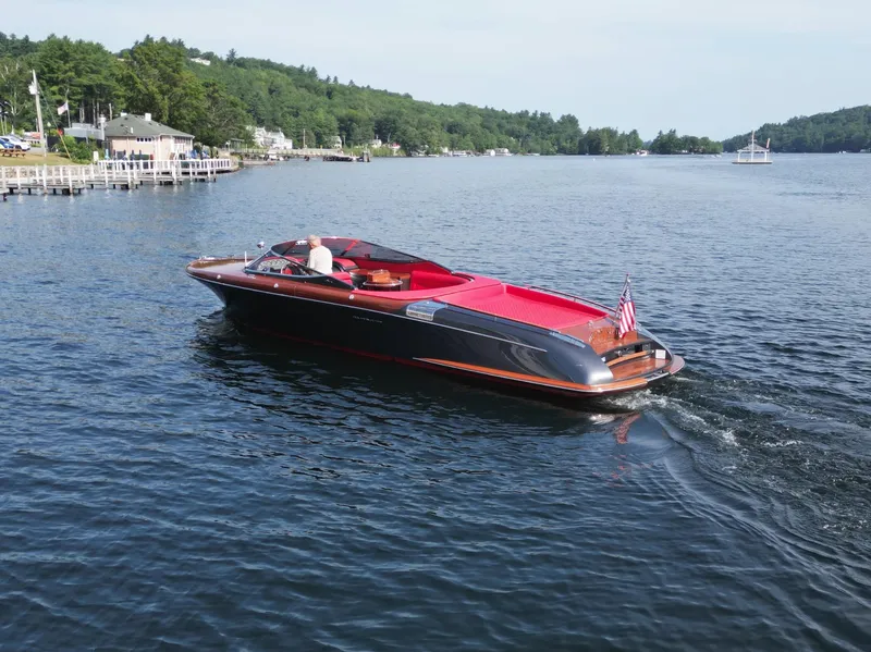 Slide: The Image of 2013 Riva Aquariva 33 luxury boat cruising on a scenic lake. - 13