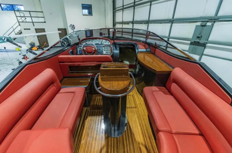 Slide: The Image of Interior of 2013 Riva Aquariva 33 with red seating and polished wood flooring. - 29