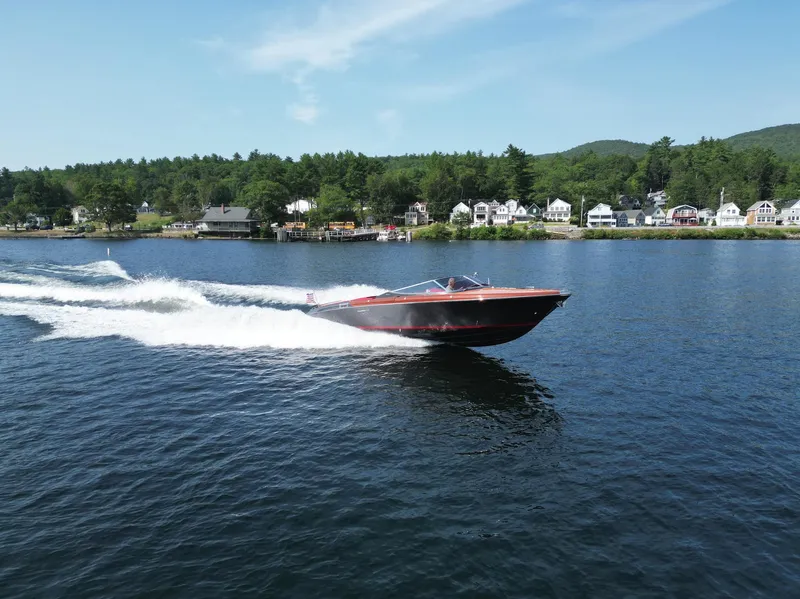 Slide: The Image of 2013 Riva Aquariva 33 cruising on a scenic lake with houses in the background. - 45