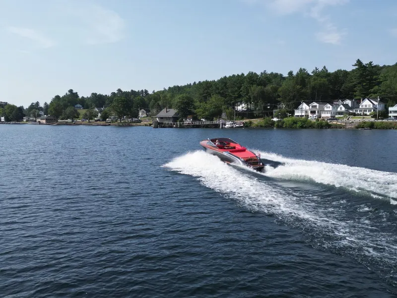 Slide: The Image of 2013 Riva Aquariva 33 speedboat cruising on a scenic lake with waterfront homes. - 46