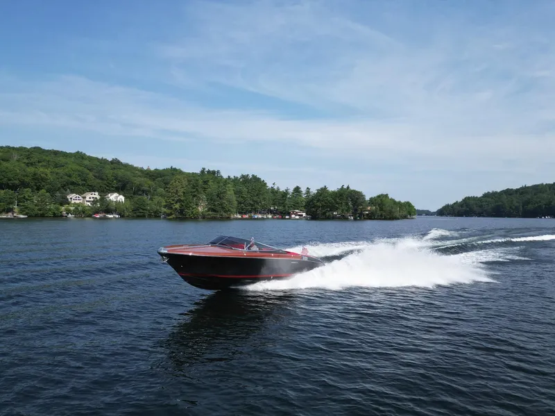 Slide: The Image of 2013 Riva Aquariva 33 speedboat cruising on a scenic lake with lush green shoreline. - 47