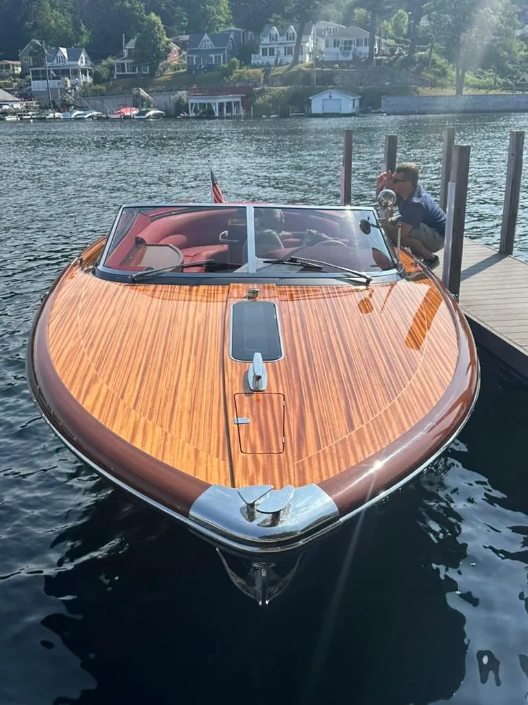 Slide: The Image of 2013 Riva Aquariva 33 boat docked on a serene lake with scenic background. - 6