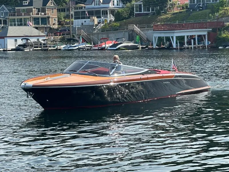 Slide: The Image of 2013 Riva Aquariva 33 boat cruising on a scenic lake near waterfront homes. - 4
