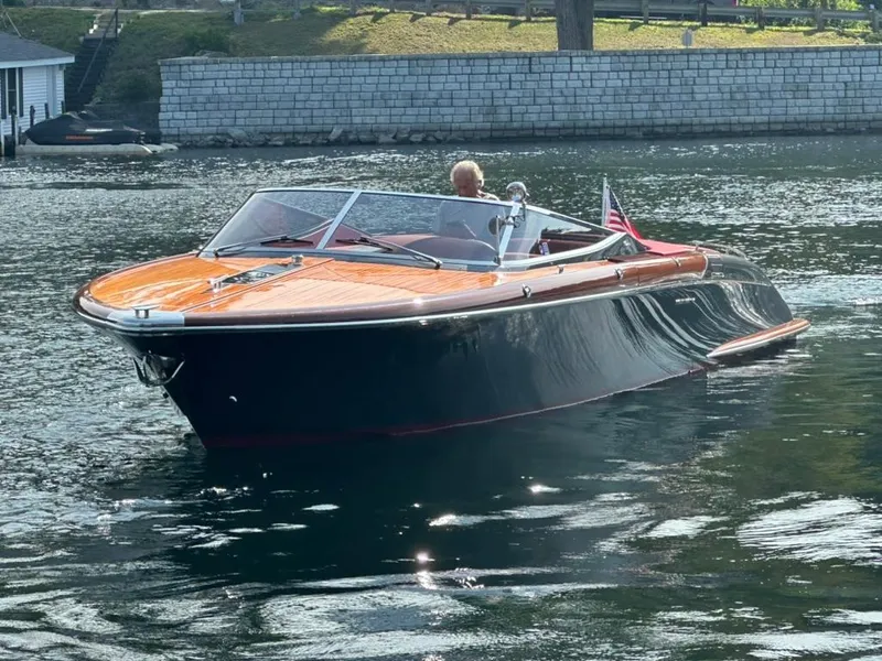 Slide: The Image of 2013 Riva Aquariva 33 luxury boat cruising on a serene waterway. - 5