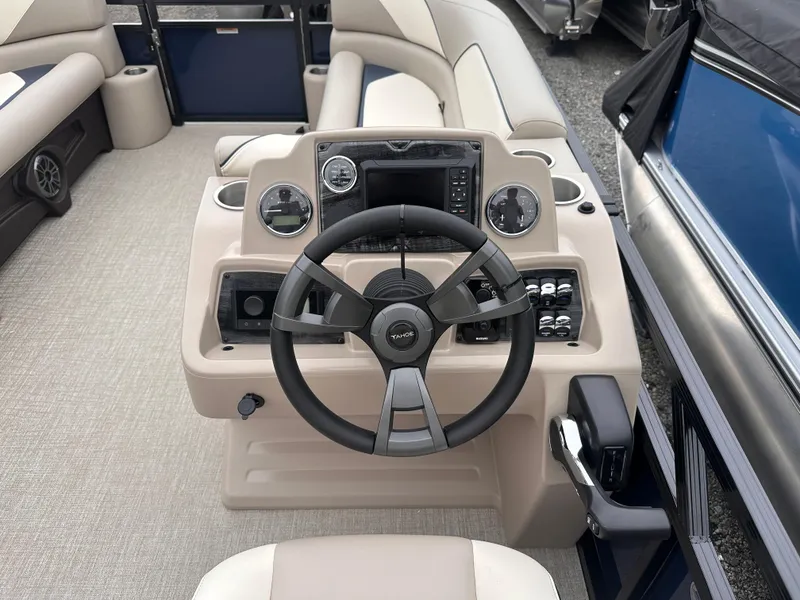 Slide: The Image of 2025 Tahoe Pontoon Sport 85 Versatile Rear Bench steering console with modern controls and beige seating. - 6