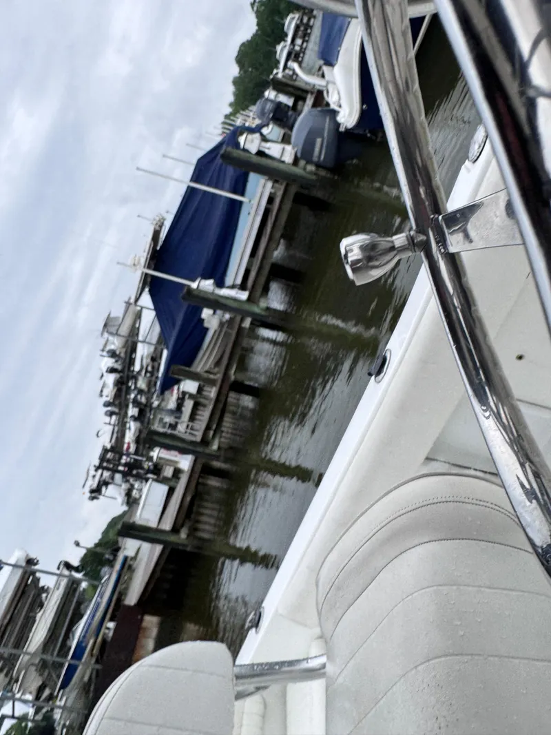 Slide: The Image of 2011 Sea Hunt Triton 225 boat docked at a marina with covered vessels. - 11