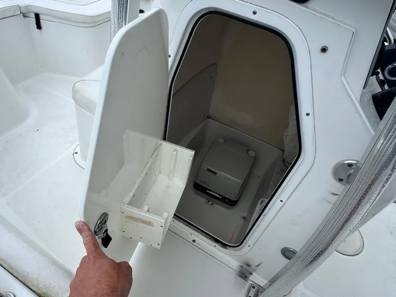 Slide: The Image of 2011 Sea Hunt Triton 225 boat with open storage compartment and portable toilet. - 13