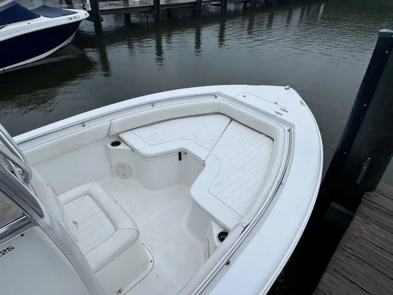 Slide: The Image of 2011 Sea Hunt Triton 225 boat with white seating, docked by calm water. - 15