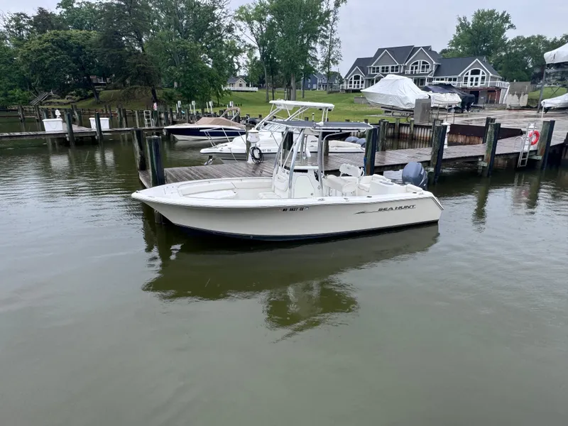 Slide: The Image of 2011 Sea Hunt Triton 225 boat docked in a serene marina setting. - 3