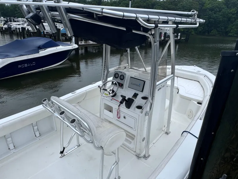 Slide: The Image of 2011 Sea Hunt Triton 225 boat with center console, docked by the water. - 6
