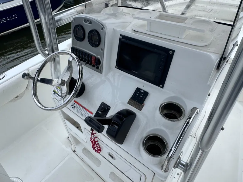 Slide: The Image of 2011 Sea Hunt Triton 225 boat console with steering wheel, gauges, and controls. - 8