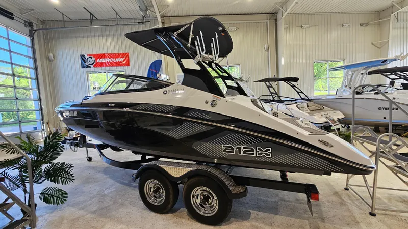 Slide: The Image of 2017 Yamaha Boats 212X in showroom, black and white design, on trailer. - 1