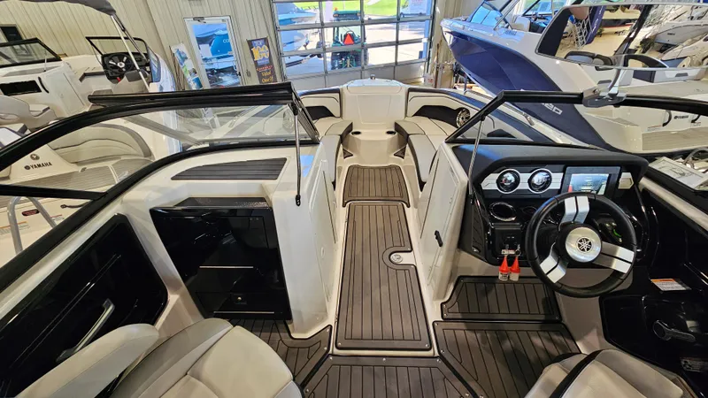 Slide: The Image of 2017 Yamaha Boats 212X interior with sleek design and modern dashboard in showroom. - 13