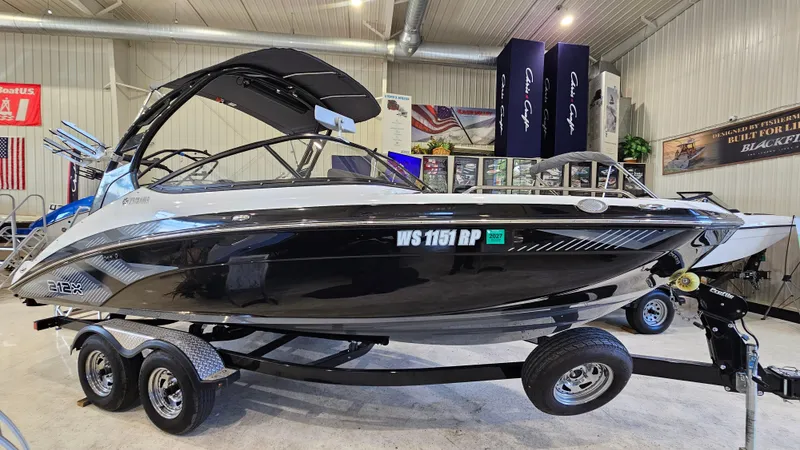 Slide: The Image of 2017 Yamaha Boats 212X on trailer in showroom, sleek black design. - 3