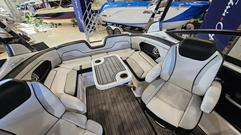 Slide: The Image of 2017 Yamaha Boats 212X interior with seating and table, showcased in a showroom. - 8