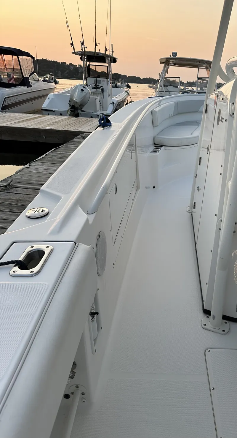 Slide: The Image of 2009 Edgewater 318CC boat docked at sunset with fishing rods visible. - 17