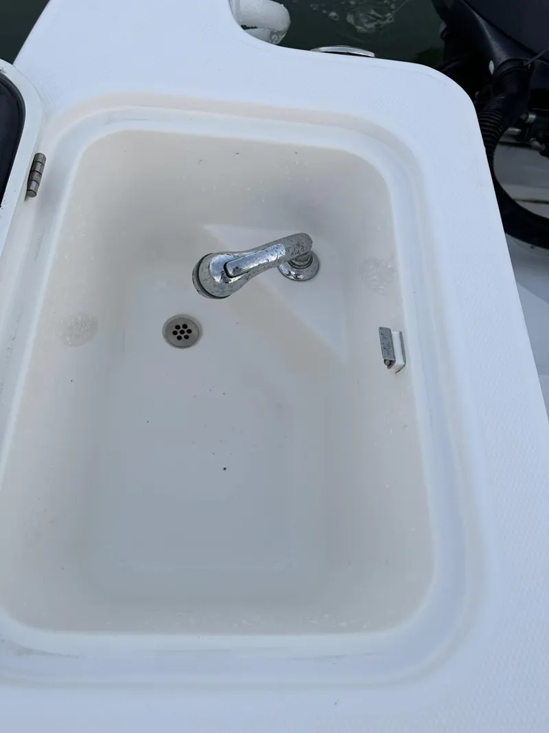 Slide: The Image of 2009 Edgewater 318CC boat sink with faucet, white basin, and drain. - 22