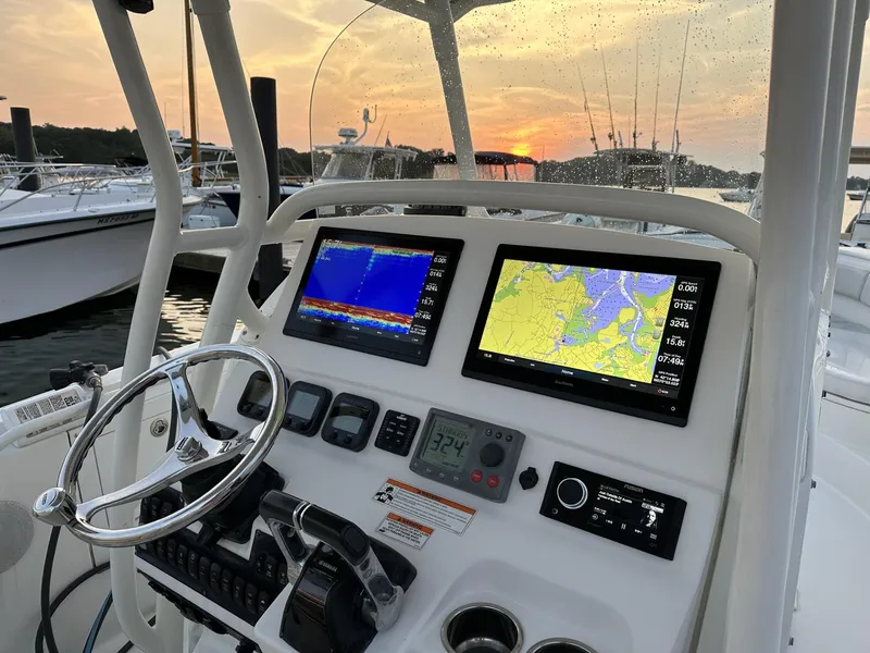 Slide: The Image of 2009 Edgewater 318CC boat dashboard with navigation screens at sunset. - 26