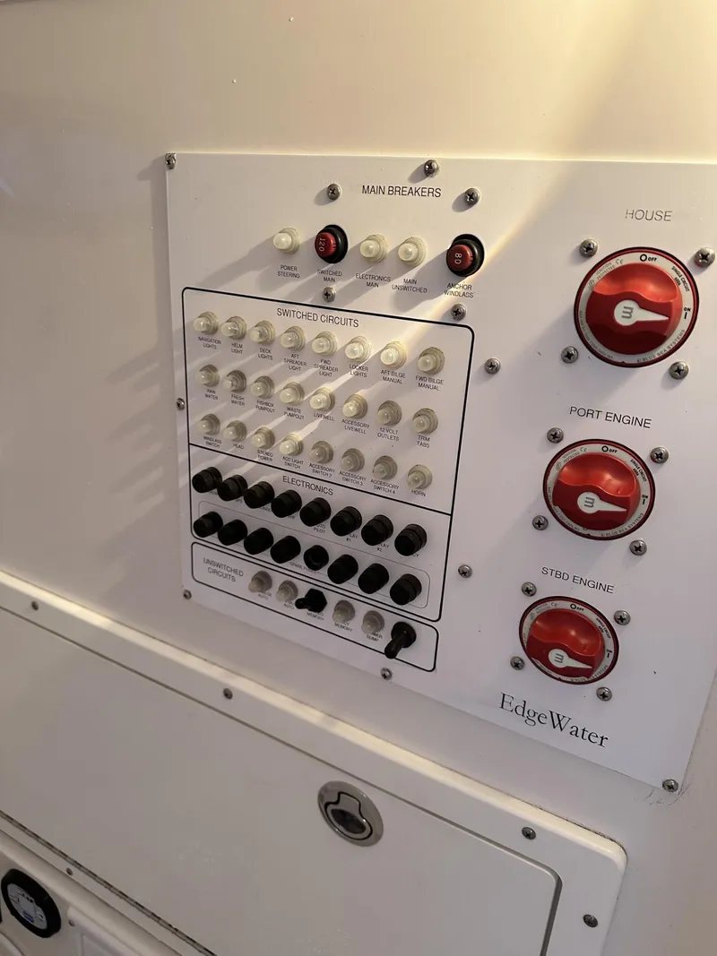 Slide: The Image of Control panel of a 2009 Edgewater 318CC boat with switches and breakers. - 32