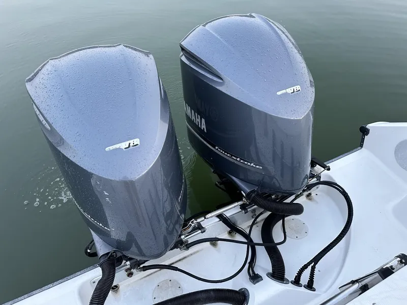 Slide: The Image of Twin Yamaha outboard motors on a 2009 Edgewater 318CC boat, resting on calm water. - 33