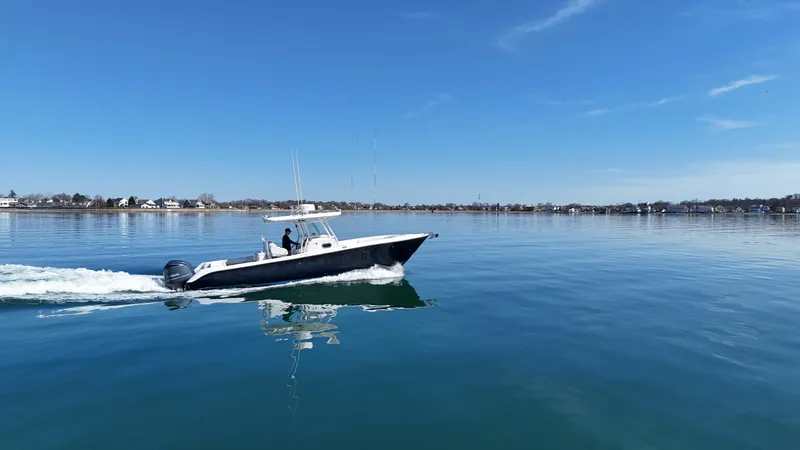 Slide: The Image of 2009 Edgewater 318CC boat cruising on calm water under clear blue sky. - 6