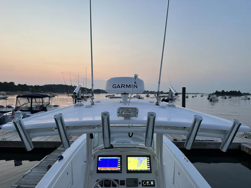 Slide: The Image of 2009 Edgewater 318CC boat with Garmin equipment at sunset, docked in a serene harbor. - 9