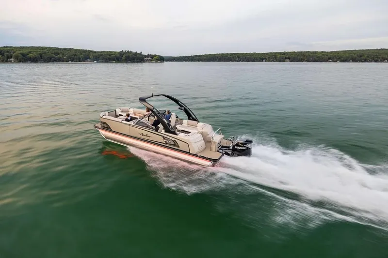 Slide: The Image of 2024 Avalon Excalibur LTD Elite Windshield boat cruising on a serene lake. - 10