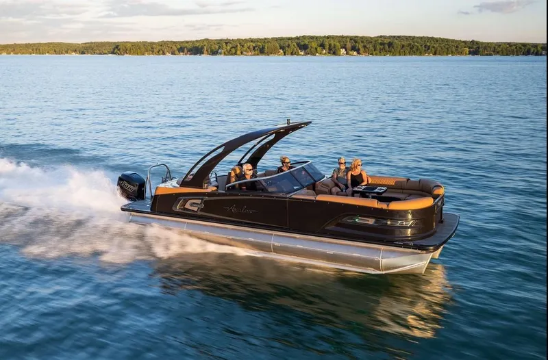 Slide: The Image of 2024 Avalon Excalibur LTD Elite Windshield boat cruising on a serene lake. - 5