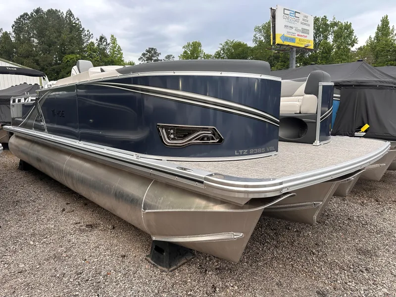 Slide: The Image of 2025 Tahoe Pontoon LTZ Versatile Rear Lounger, sleek design, parked on gravel. - 0