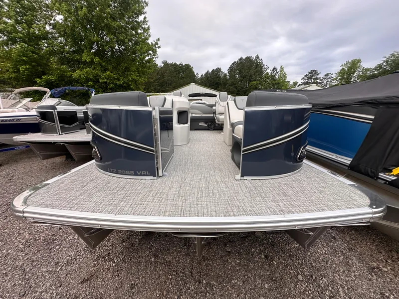 Slide: The Image of 2025 Tahoe Pontoon LTZ Versatile Rear Lounger, spacious deck, parked outdoors. - 1