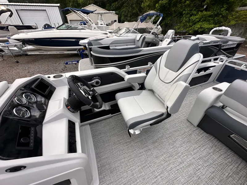 Slide: The Image of 2025 Tahoe Pontoon LTZ Versatile Rear Lounger with modern helm and seating, docked among other boats. - 8