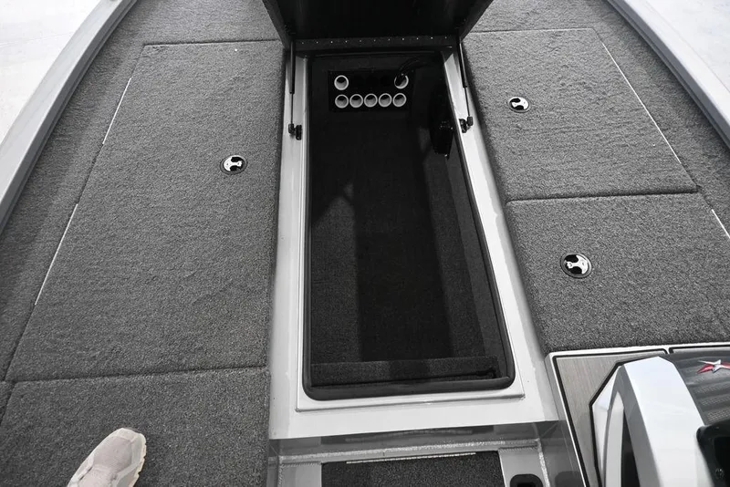 Slide: The Image of 2024 Vexus AVX2080 boat interior with open storage compartment and carpeted flooring. - 2