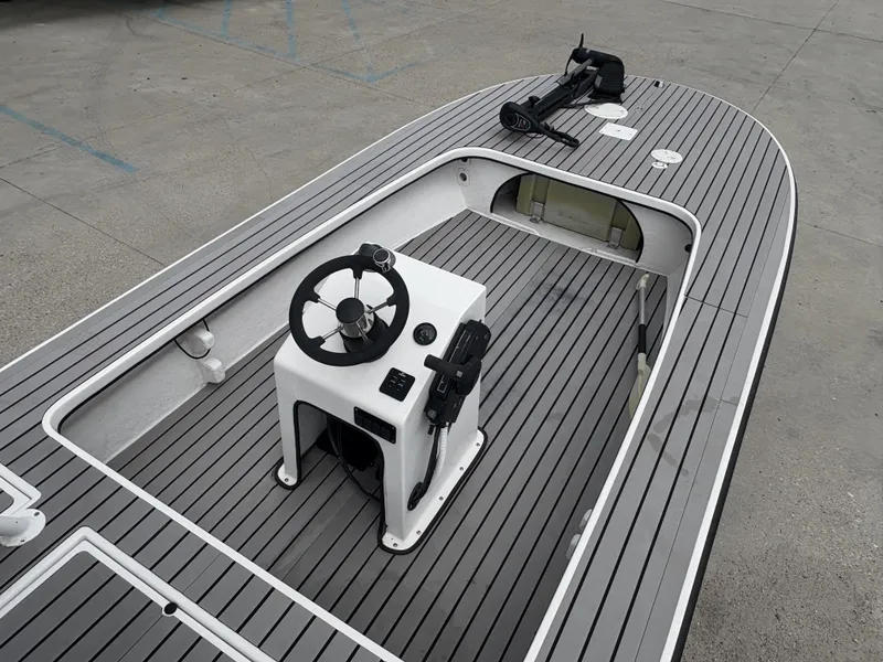 Slide: The Image of 2004 Custom Mitizi Skiff 17 boat with sleek gray deck and central steering console. - 4