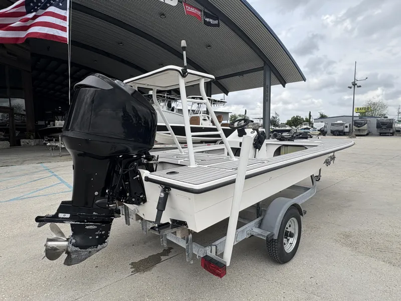 Slide: The Image of 2004 Custom Mitizi Skiff 17 boat on trailer, parked outdoors near dealership. - 6