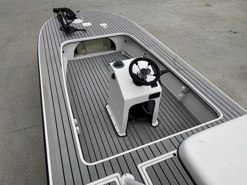 Slide: The Image of 2004 Custom Mitizi Skiff 17 boat interior with steering console and gray deck. - 8