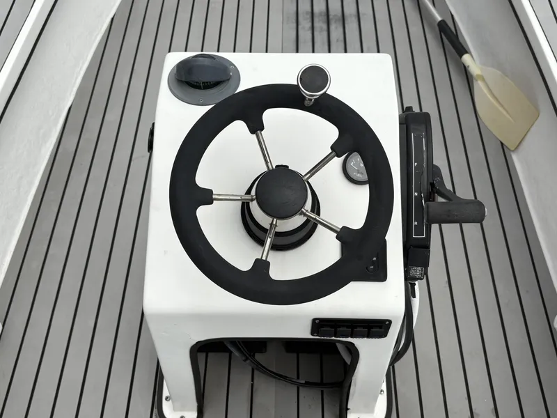 Slide: The Image of Steering console of a 2004 Custom Mitizi Skiff 17 boat on a wooden deck. - 9