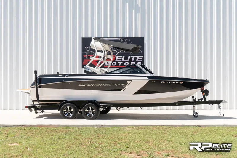 Slide: The Image of 2014 Nautique Super Air Nautique 230 boat on trailer, displayed outdoors. - 1