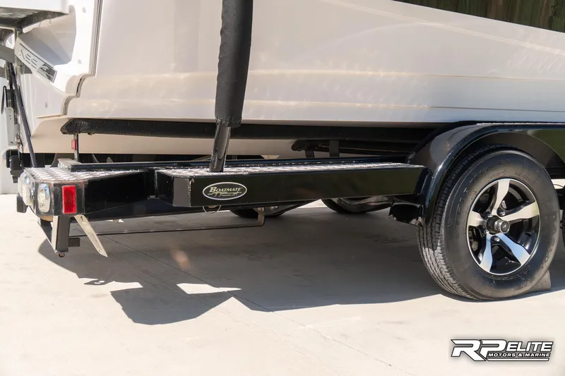 Slide: The Image of 2014 Nautique Super Air Nautique 230 boat trailer with black frame and chrome wheels. - 11