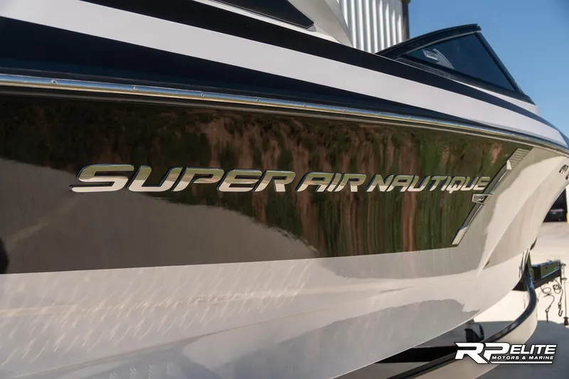 Slide: The Image of 2014 Nautique Super Air Nautique 230 boat side view with logo detail. - 13