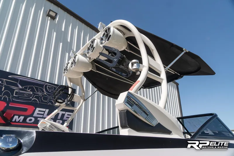 Slide: The Image of 2014 Nautique Super Air Nautique 230 boat with tower speakers and bimini top. - 14