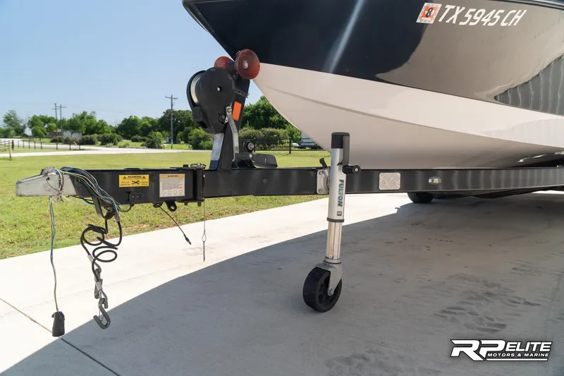 Slide: The Image of 2014 Nautique Super Air Nautique 230 boat on trailer, parked on concrete. - 18