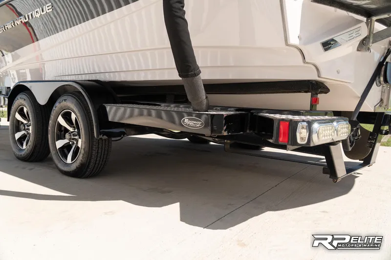 Slide: The Image of 2014 Nautique Super Air Nautique 230 boat trailer with dual axles and sleek design. - 24