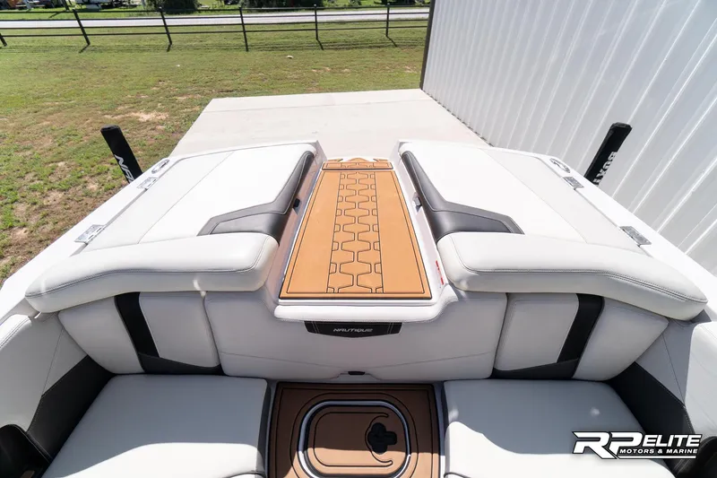 Slide: The Image of 2014 Nautique Super Air Nautique 230 boat interior with cushioned seating and teak accents. - 34