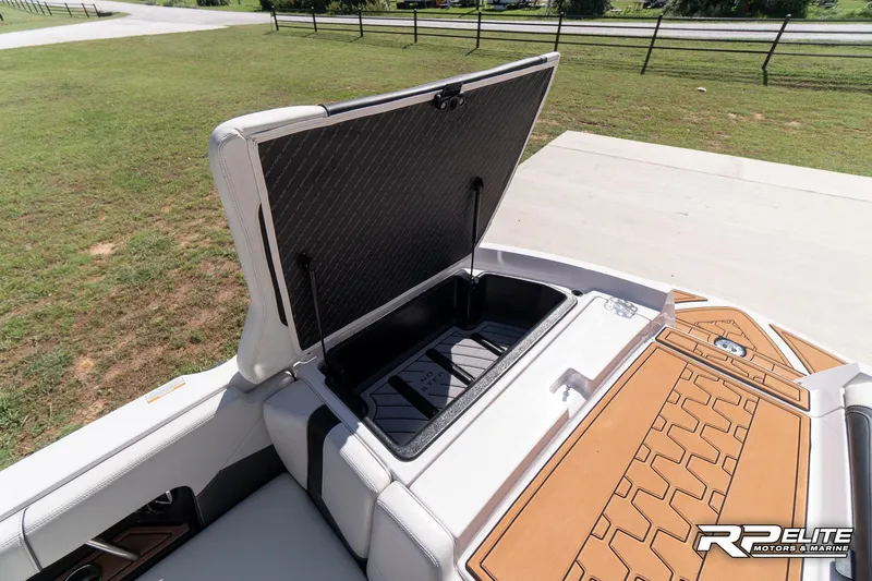 Slide: The Image of 2014 Nautique Super Air Nautique 230 boat storage compartment open, showcasing interior space. - 36