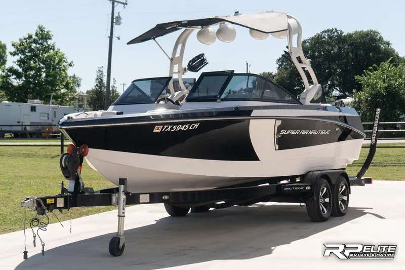 Slide: The Image of 2014 Nautique Super Air Nautique 230 boat on trailer, parked outdoors. - 4