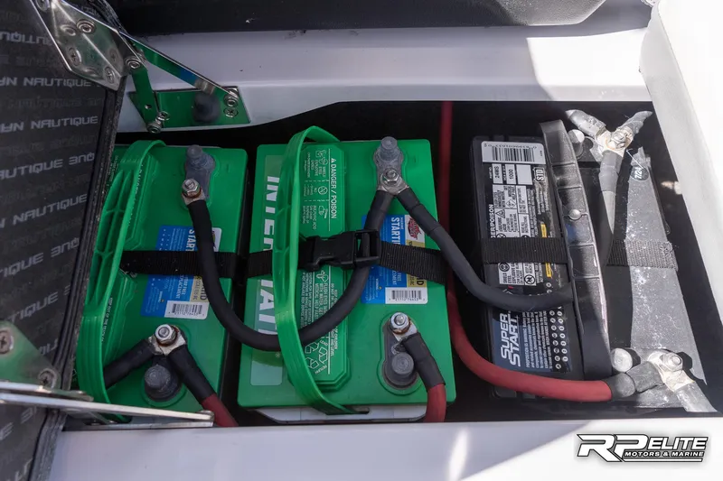 Slide: The Image of 2014 Nautique Super Air Nautique 230 battery compartment with green and black batteries. - 44
