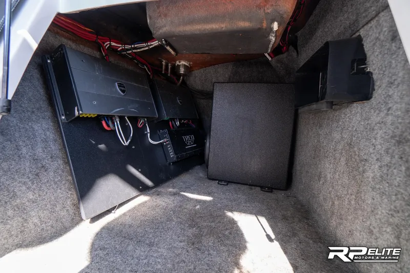 Slide: The Image of 2014 Nautique Super Air Nautique 230 interior storage with audio equipment and wiring. - 47