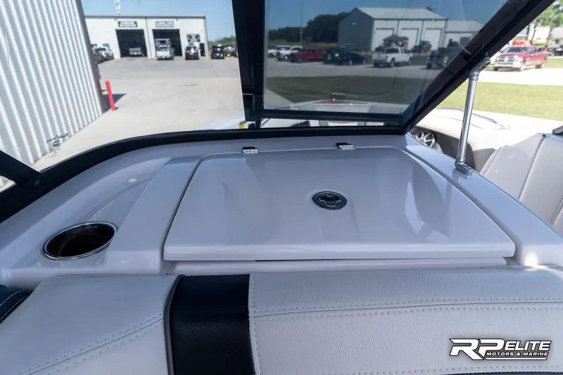 Slide: The Image of 2014 Nautique Super Air Nautique 230 boat interior with storage compartment and cup holder. - 48