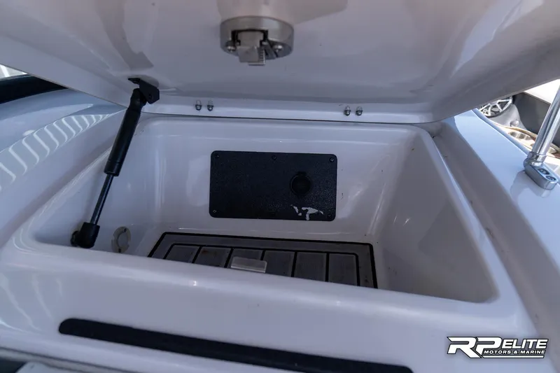 Slide: The Image of 2014 Nautique Super Air Nautique 230 storage compartment with open lid and hydraulic support. - 49