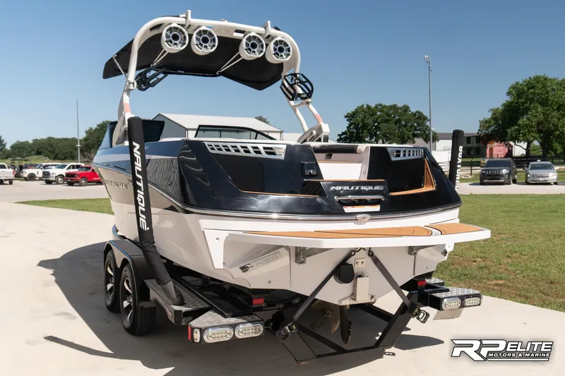 Slide: The Image of 2014 Nautique Super Air Nautique 230 boat on trailer, rear view, outdoor setting. - 6